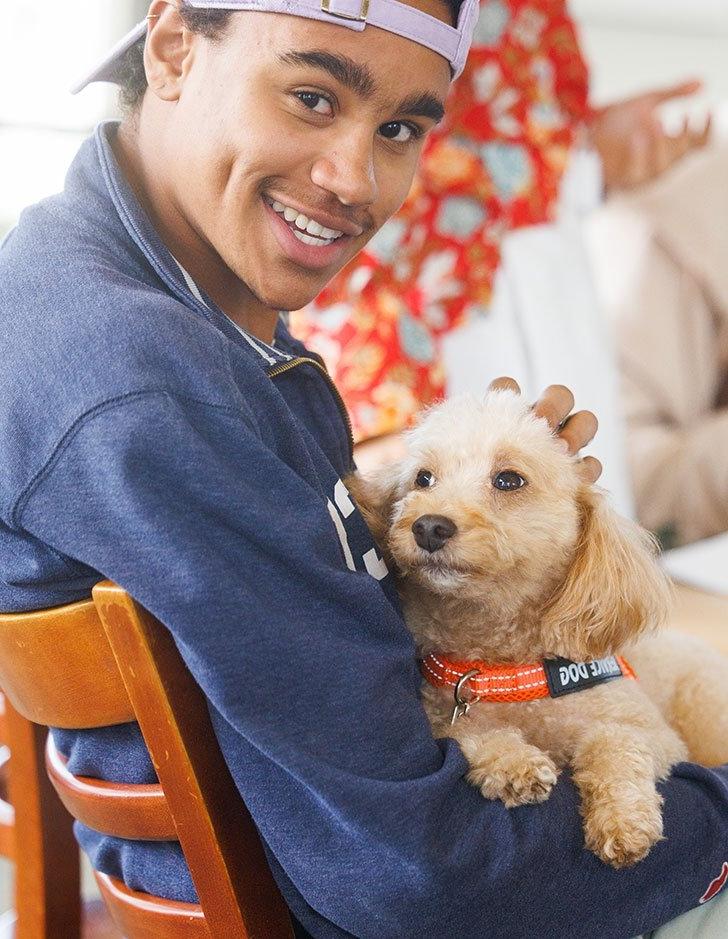 a student sits with a support dog on their lap